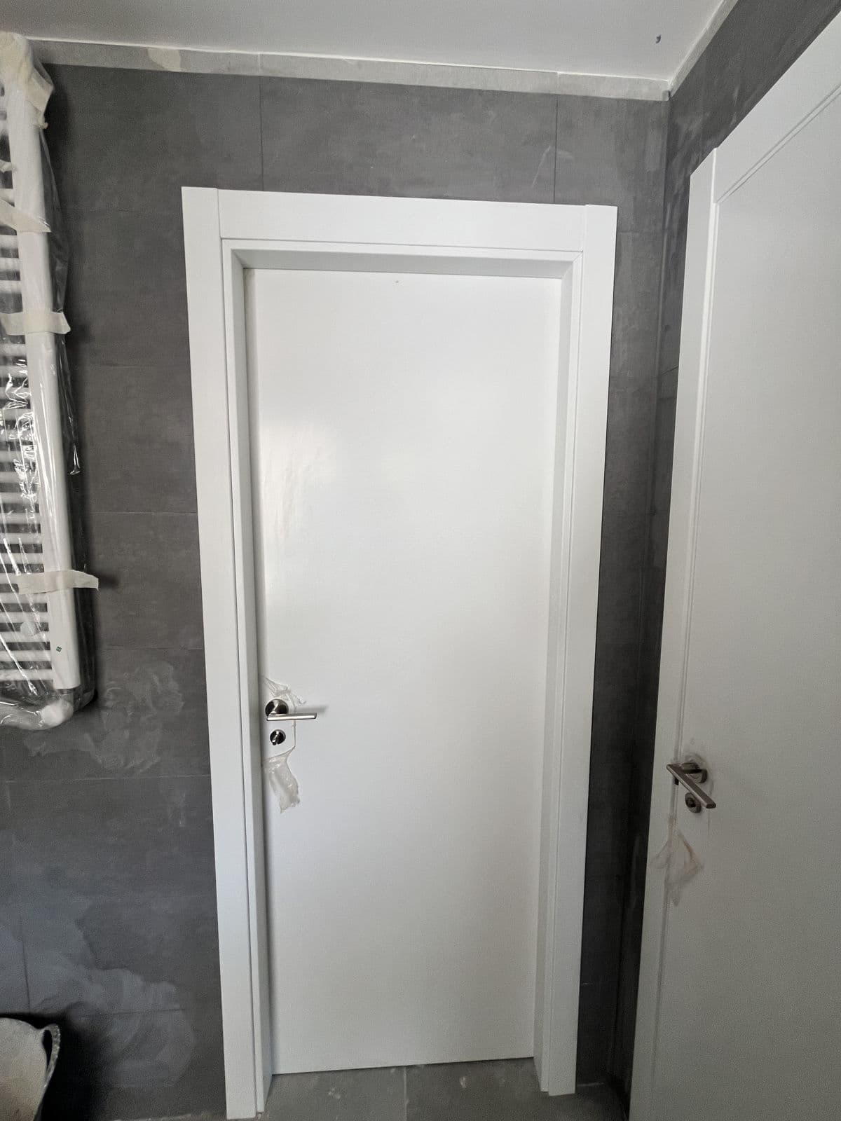 Puerta de paso blanca lacada recién instalada con su marco
